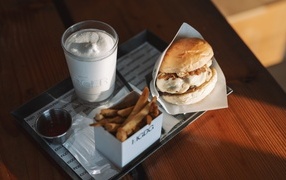 Гамбургер, картофель фри и  напиток на столе