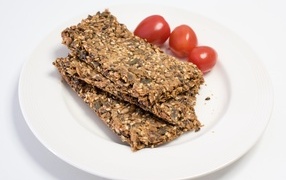 Полезны злаковые хлебцы на тарелке с помидорами
