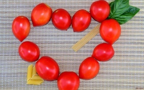 Сердце из помидоров на столе с макаронами