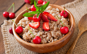 Овсяная каша с ягодами в деревянной миске