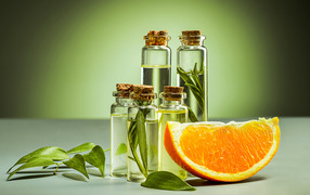 Апельсиновое масло на зеленом фоне с апельсинами