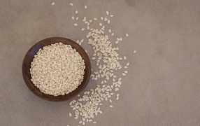 Зерна кунжута в деревянной миске на столе