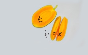 Разрезанная папайя на сером фоне