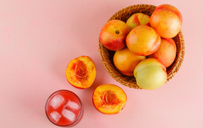 Свежий нектарин в корзине на розовом столе