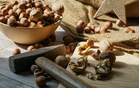 Фундук и грецкие орехи на столе с молотком