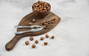 Лесные орехи на сером столе с разделочной доской