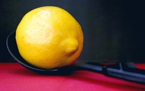 Большой желтый лимон на чайной ложке