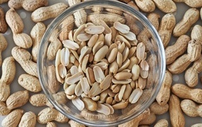 Арахис в стеклянной тарелке на столе 