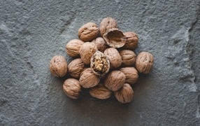 Куча грецких орехов на сером столе