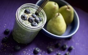 Смузи с ягодами черники на столе с грушами