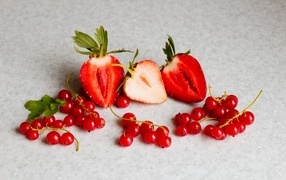 Ягоды клубники с красной смородиной на сером столе