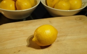 Желтый лимон на деревянной доске на столе