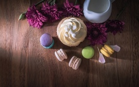 Аппетитные сладкие пирожные с цветами хризантемы на столе