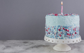 Birthday cake in blue glaze with one candle
