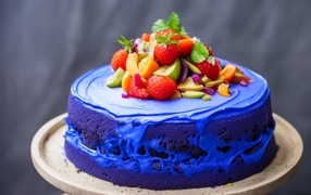 Голубой торт с ягодами на сером фоне