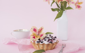 Черничное пирожное с цветами альстромерии на розовом фоне