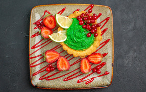 Торт с зеленым кремом и ягодами на тарелке