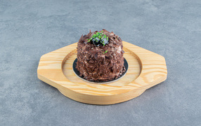 Шоколадное пирожное на деревянной доске на сером фоне