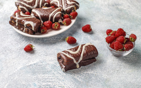 Шоколадные рулетики с ягодами малины на столе