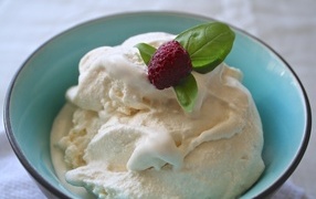 Сливочное мороженое в тарелке с ягодой малины