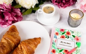 Круассаны на столе с кофе и цветами
