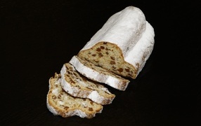 Кекс с сахарной пудре с изюмом на черном фоне