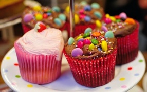 Cupcakes with pink cream and colorful candies