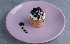 Маффин с шоколадным топпингом на большой тарелке