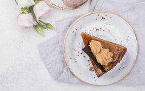 Кусок торта на тарелке на столе с цветами