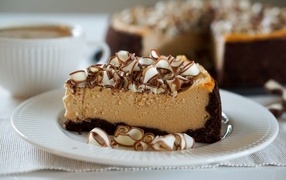 Кусок торта с шоколадной стружкой на белой тарелке