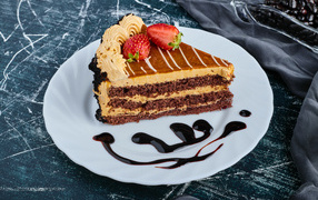 Кусок торта с клубникой на большой белой тарелке