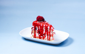 Кусок торта с клубничным сиропом на голубом фоне