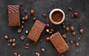 Кусочки пирожных на сером столе с шоколадными зернами