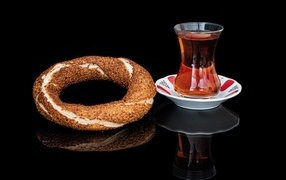Крендель с чаем на черном фоне