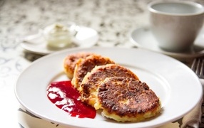 Румяные сырники на тарелке с джемом на завтрак