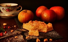 Песочный яблочный пирог на столе с яблоками