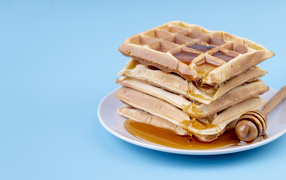 Сладкие вафли с медом на голубом фоне