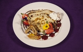 Тонкие блинчики с кремом и ягодами на тарелке