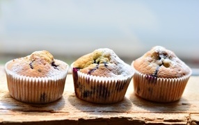 Три вкусных сладких кекса с сахарной пудрой на столе