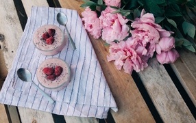 Два стакана с десертом на лавке с букетом пионов