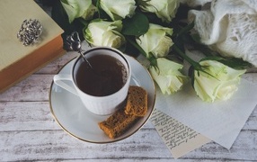 Чашка кофе на столе с букетом белых роз