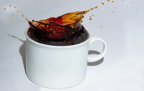 Чашка кофе с брызгами на сером столе