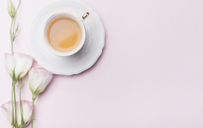 Чашка чая на розовом фоне с цветами эустомы