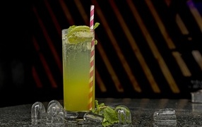 Зеленый коктейль мохито в высоком стакане со льдом