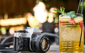 Ретро фотоаппарат с коктейлем на столе
