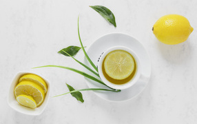 Чай в чашке на столе с кислым лимоном