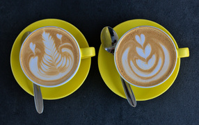 Две большие чашки капучино с рисунками на пене