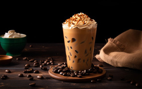 Напиток со взбитыми сливками на столе с кофейными зернами