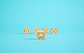 Деревянные кубики со смайлами на голубом фоне