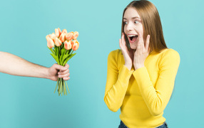 Красивой девушке дарят букет тюльпанов
